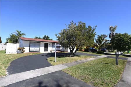 A house with a driveway and trees

Description automatically generated